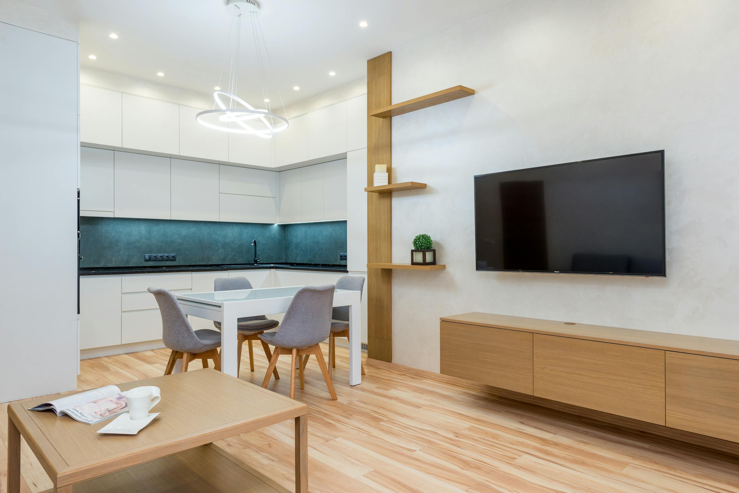 A sleek, contemporary kitchen and living room with minimalist design, featuring clean lines and bright lighting.